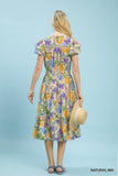 Woman wearing a floral dress against a light blue background