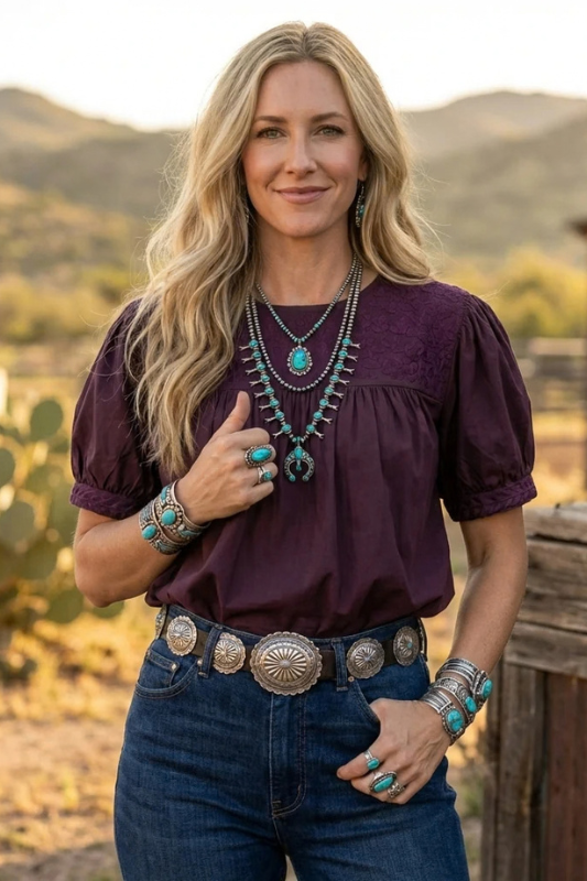 Woman in maroon blouse with mountain background.