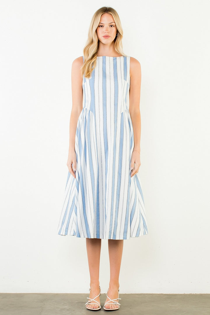 Woman wearing a blue and white striped dress against a white background