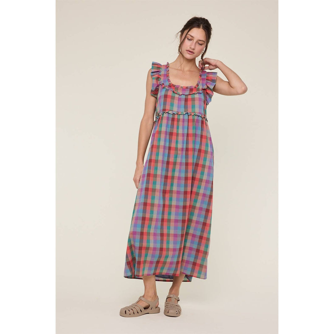 Woman wearing a colorful plaid dress on a beige background