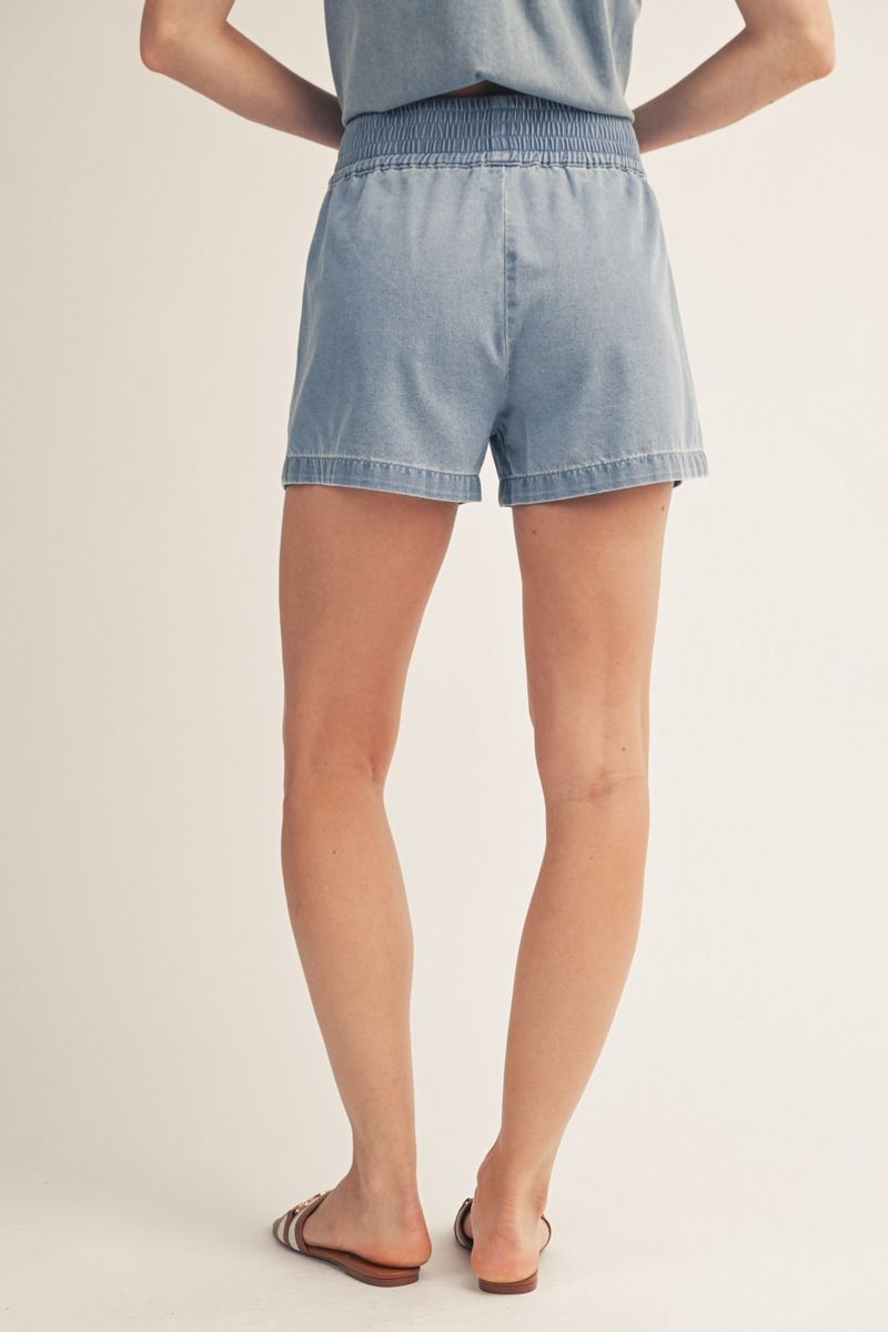 Light blue denim shorts worn by a person on a plain background