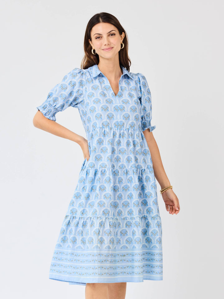 Woman wearing a blue patterned dress on a white background