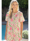 Woman wearing a floral dress standing by a poolside.