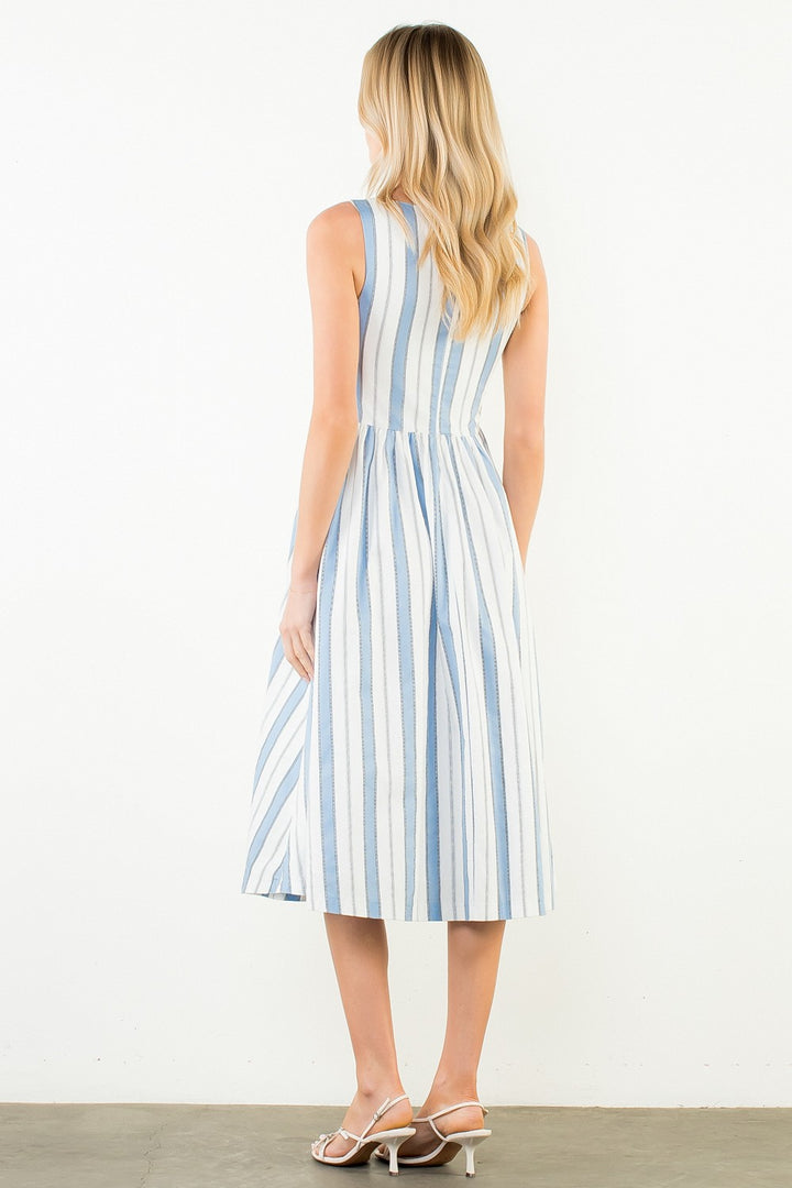 Woman wearing a blue and white striped dress on a plain background