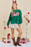 Woman wearing a green sweater with plaid design, white skirt, and brown boots in a festive setting.
