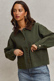 Woman wearing a green jacket with a neutral background