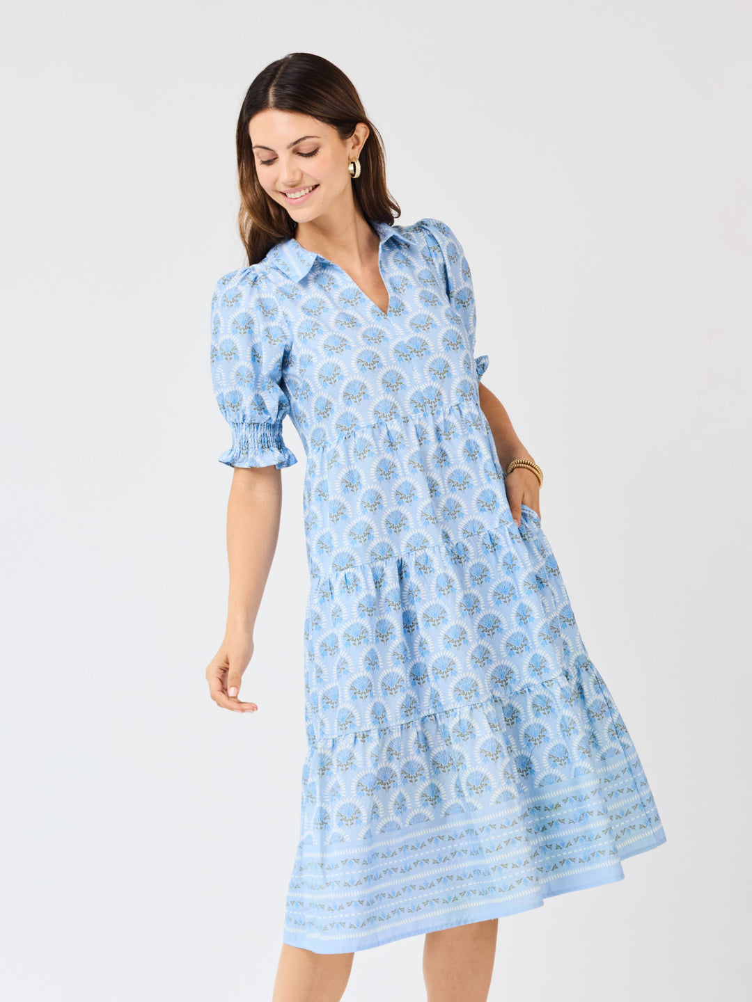 Woman wearing a blue patterned dress on a white background