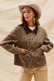 Woman wearing a leopard print sweater and beige hat against a beige background