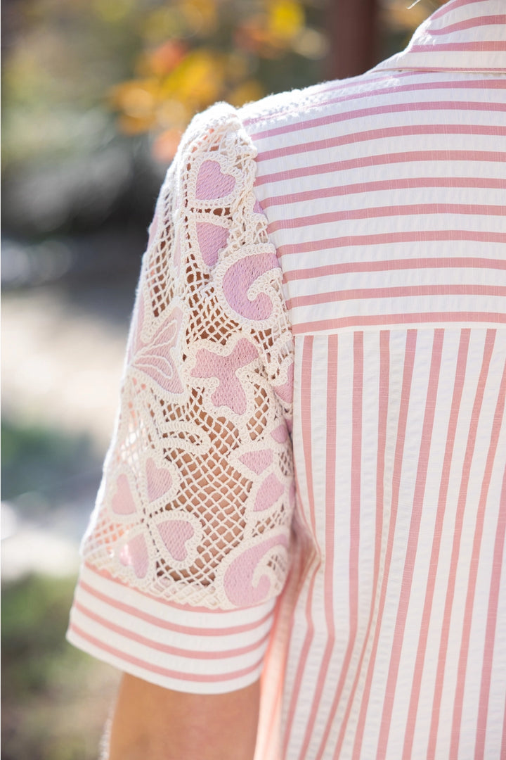 Woman wearing a lace blouse with floral patterns outdoors