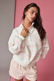 Woman wearing a white and pink striped hoodie and shorts against a pink background