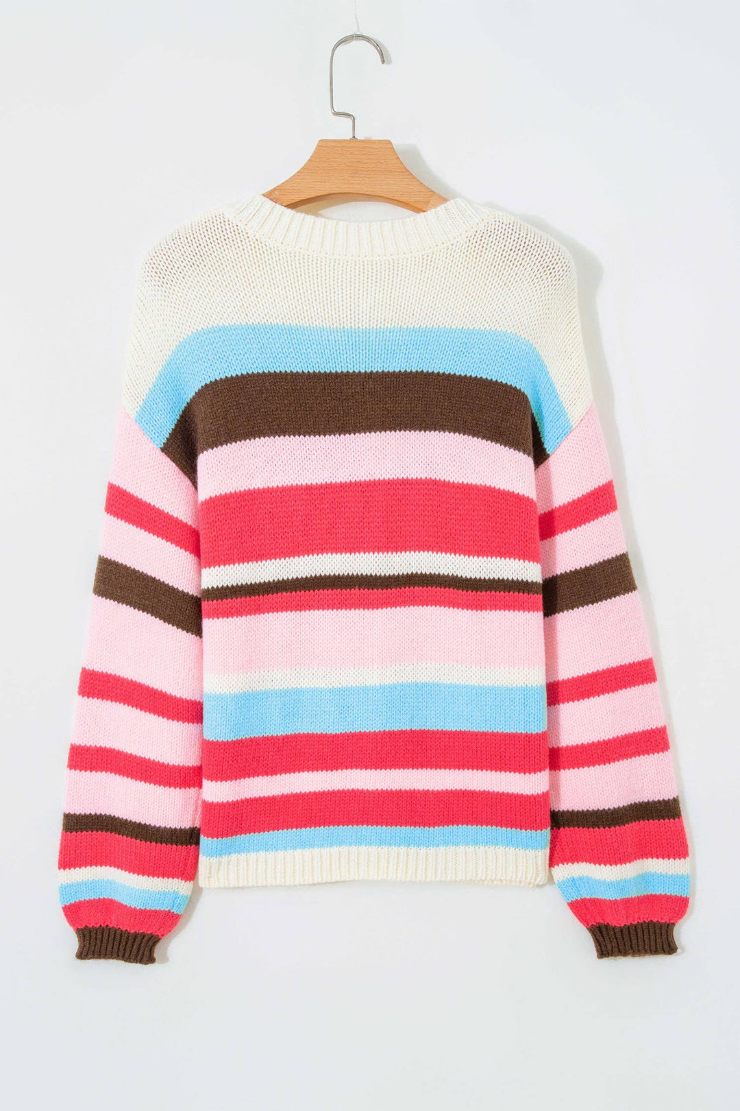 A multicolor striped knit sweater with a cream body, pink and light blue horizontal stripes across the chest, brown and pink stripes on the sleeves, and ribbed cuffs and hem, hanging on a wooden hanger against a light gray background.