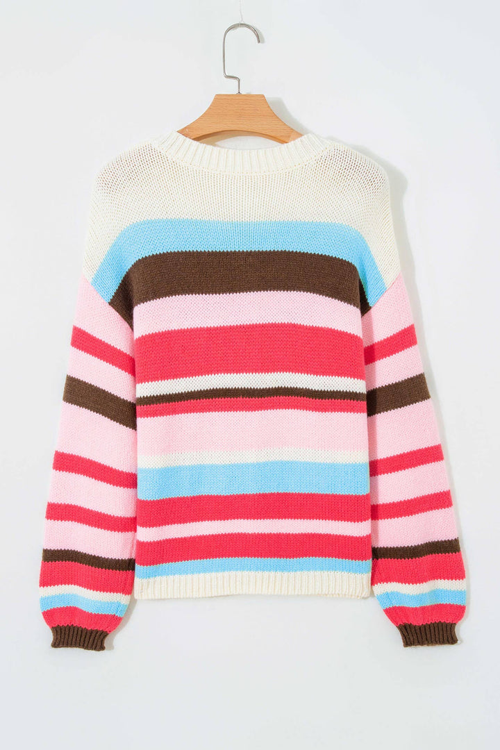 A multicolor striped knit sweater with a cream body, pink and light blue horizontal stripes across the chest, brown and pink stripes on the sleeves, and ribbed cuffs and hem, hanging on a wooden hanger against a light gray background.
