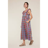 Woman wearing a colorful plaid dress on a beige background