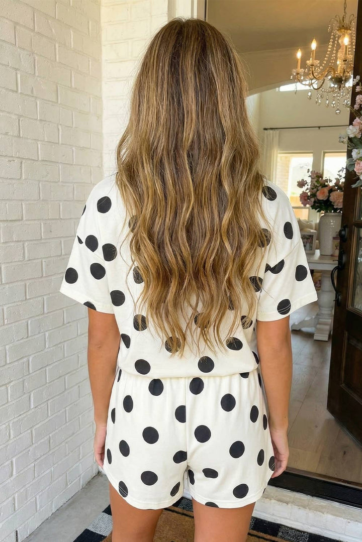 Woman wearing a polka dot outfit standing in a home interior.