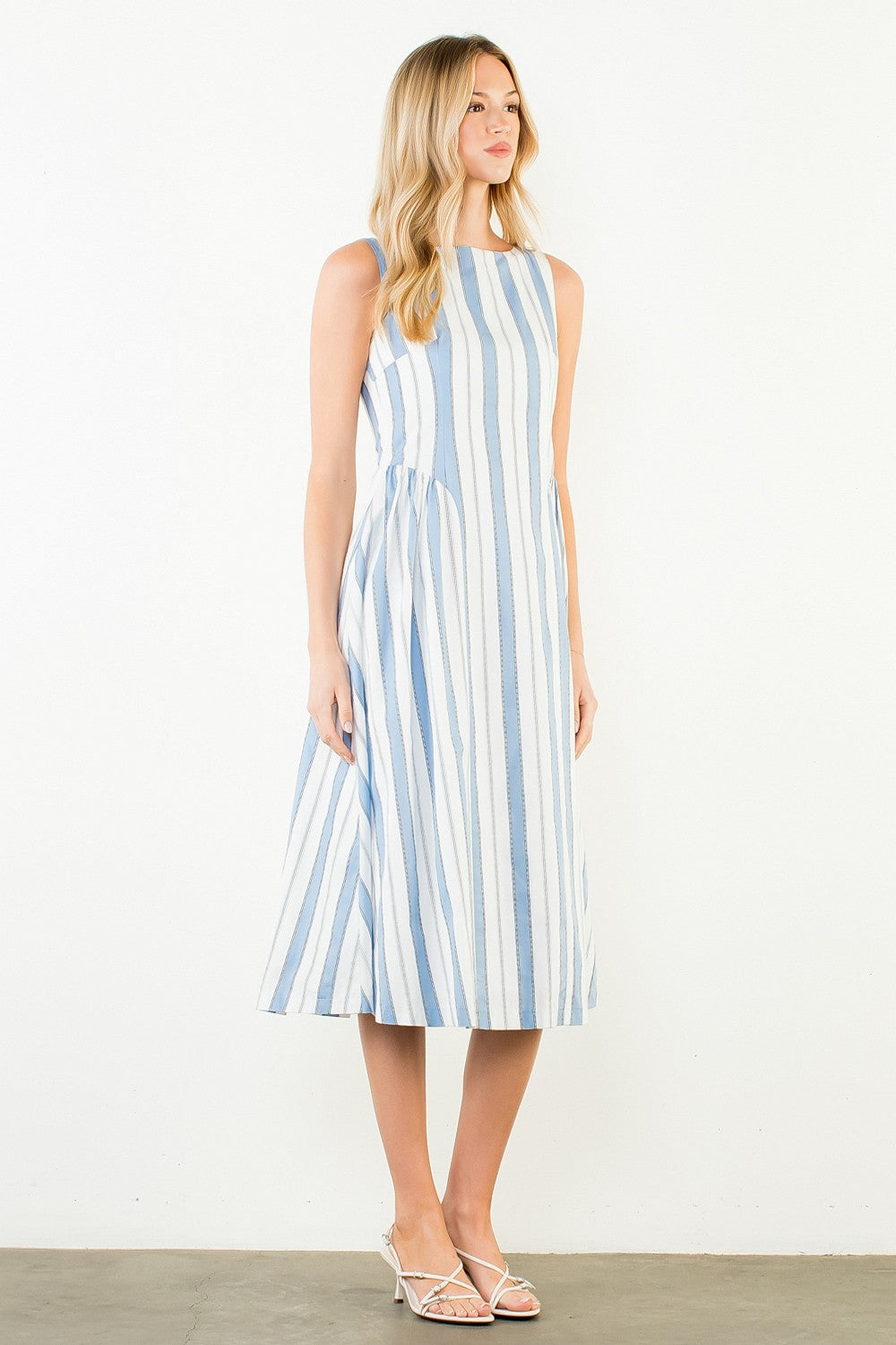 Woman wearing a blue and white striped dress against a white background