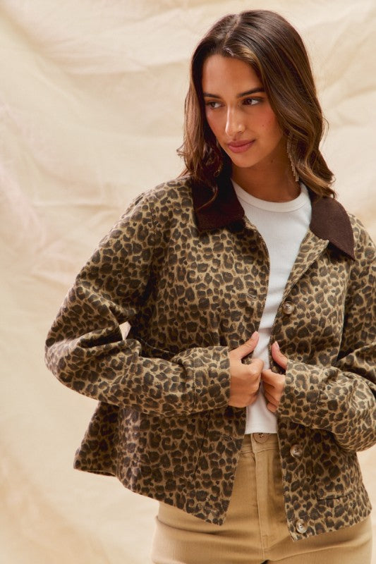 Woman wearing a leopard print jacket with a plain background