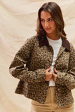 Woman wearing a leopard print jacket with a plain background