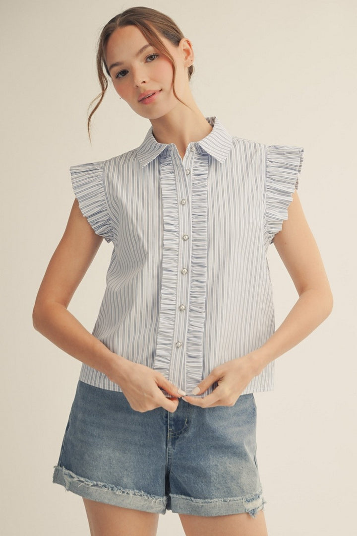 Woman wearing a sleeveless striped shirt and denim shorts on a beige background