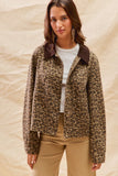 Woman wearing a leopard print jacket with a brown collar on a beige background
