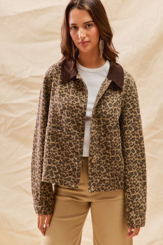 Woman wearing a leopard print jacket with a brown collar on a beige background