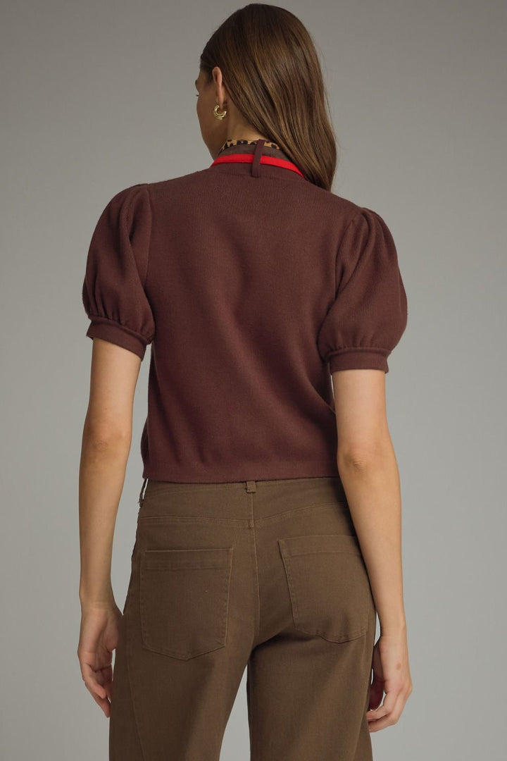Person wearing a brown top and pants on a plain background