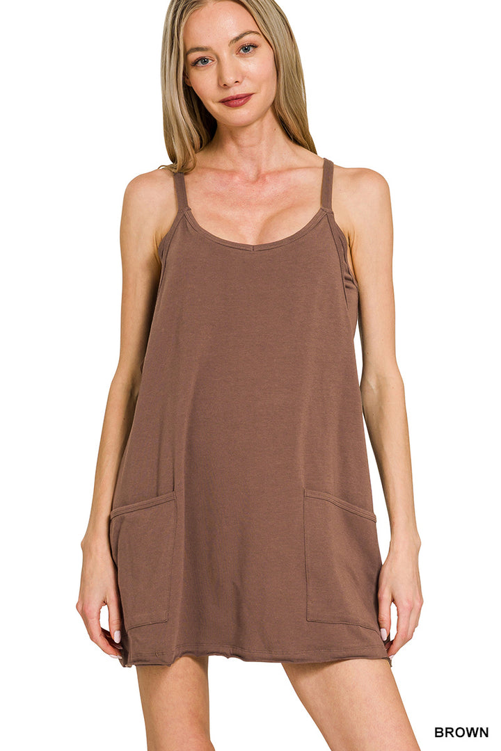 Woman wearing a brown sleeveless dress with pockets on a white background