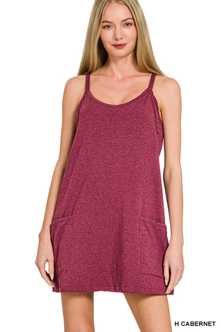 Woman wearing a maroon tank dress on a white background