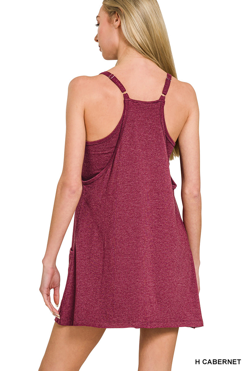 Woman wearing a maroon dress with thin straps on a white background