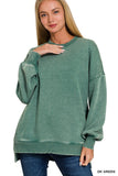 Woman wearing a dark green sweater with text 'DK GREEN' at the bottom right corner.