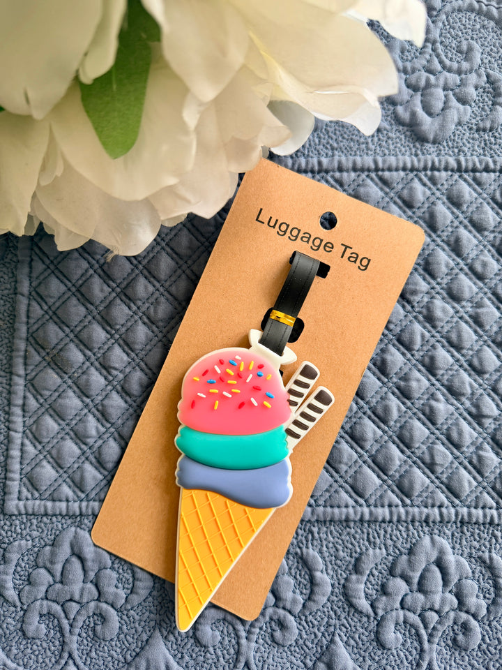 Ice cream cone luggage tag on a textured surface with flowers in the background