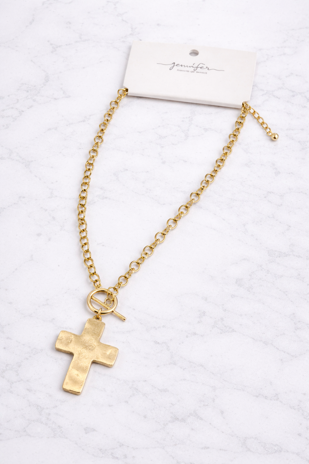 Gold necklace with a cross pendant on a white background