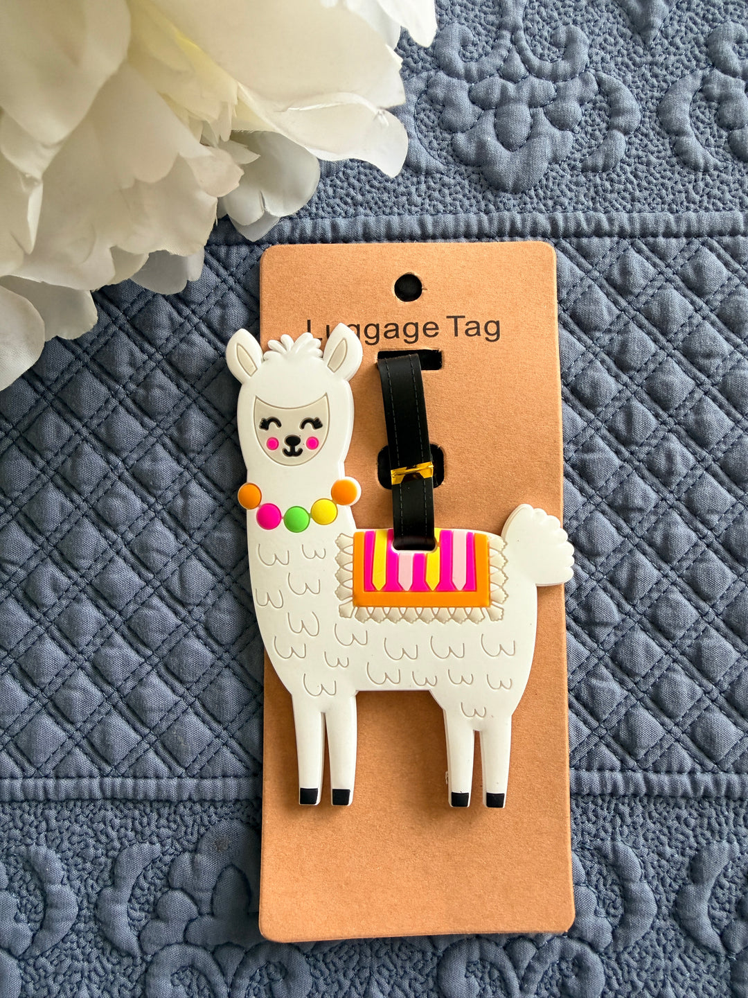 Luggage tag with llama design on a textured gray surface