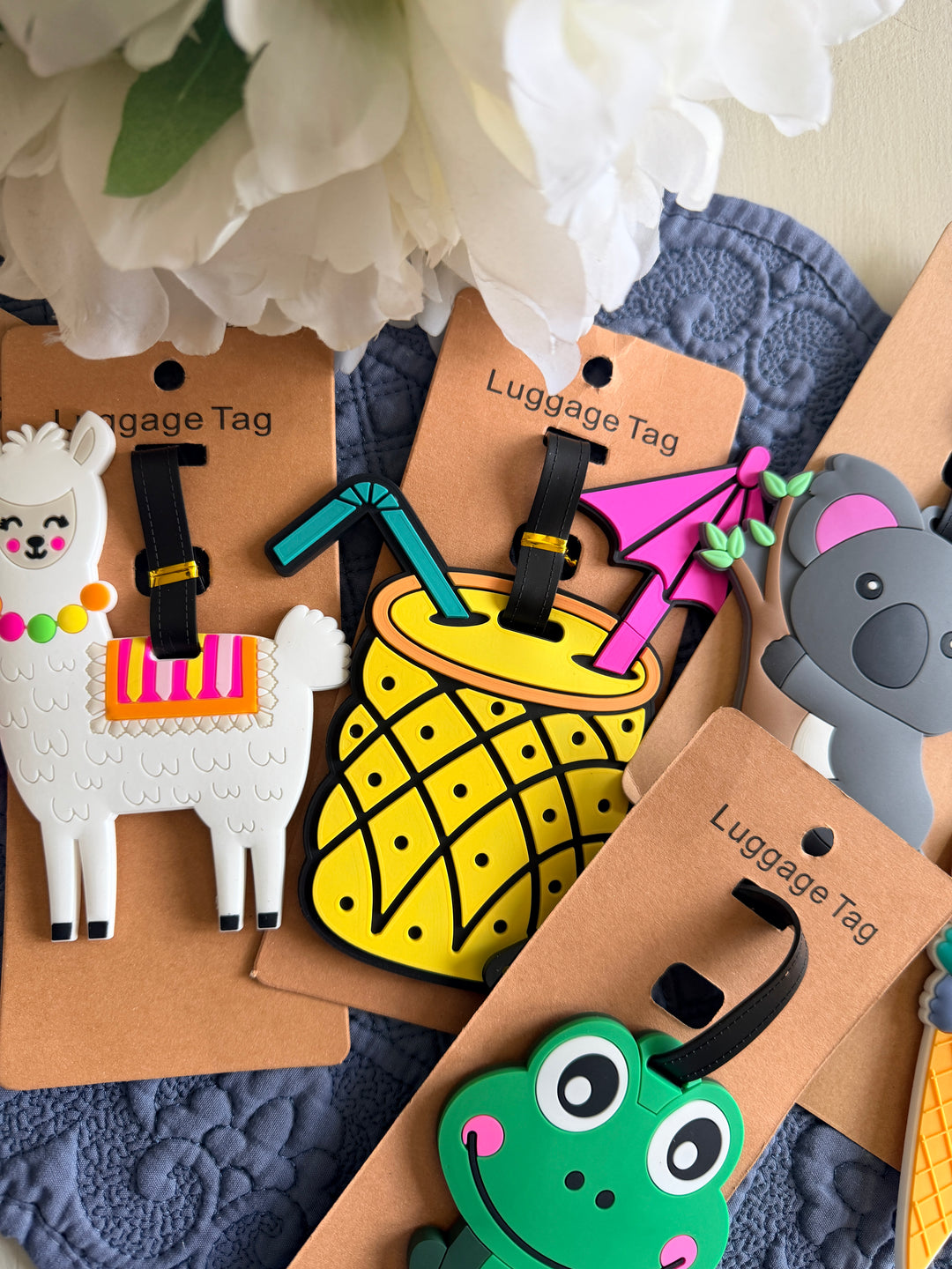 Colorful luggage tags with animal designs on a textured surface.