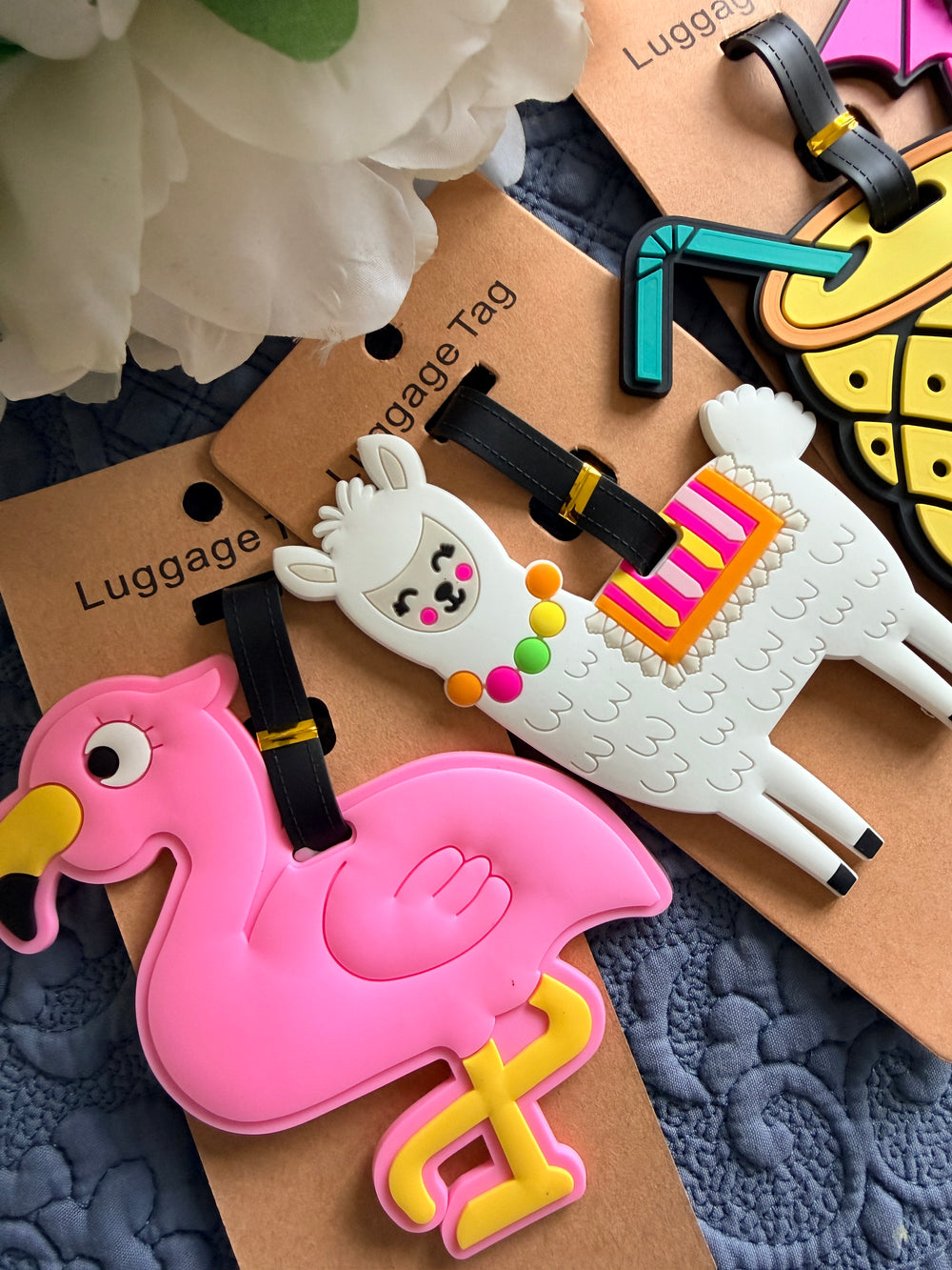 Colorful luggage tags shaped like animals on a textured surface