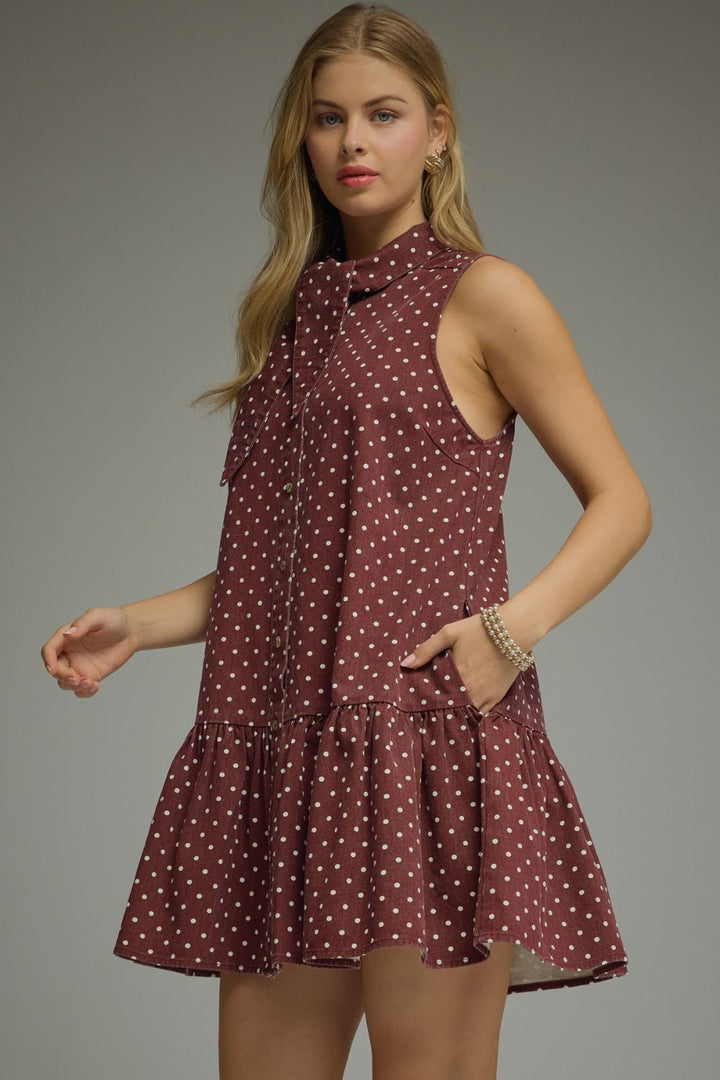Woman wearing a polka dot dress against a gray background