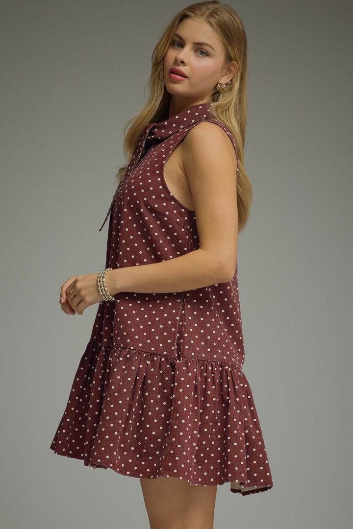 Woman wearing a polka dot dress against a gray background