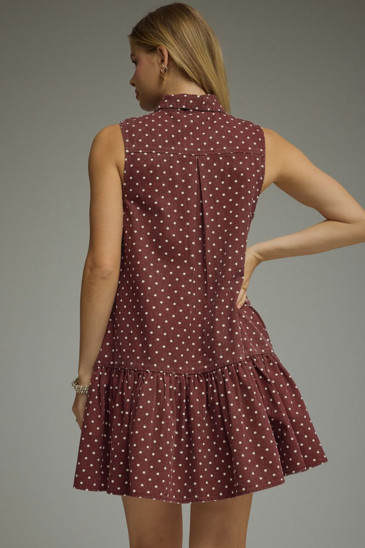 Woman wearing a patterned dress against a gray background