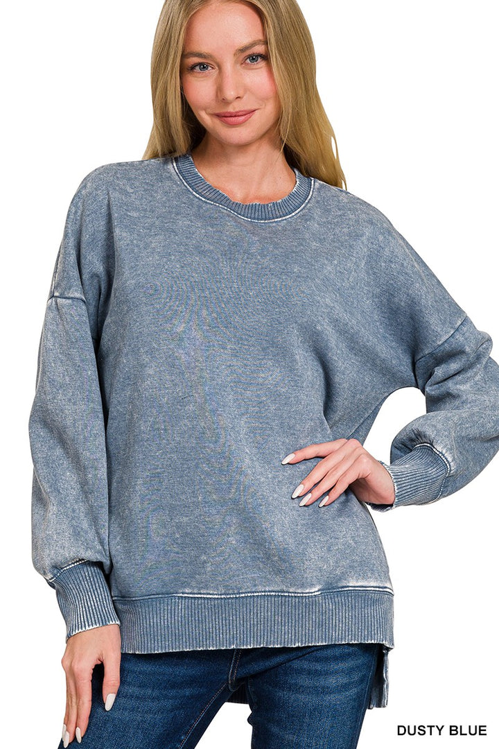 Woman wearing a dusty blue sweater on a white background