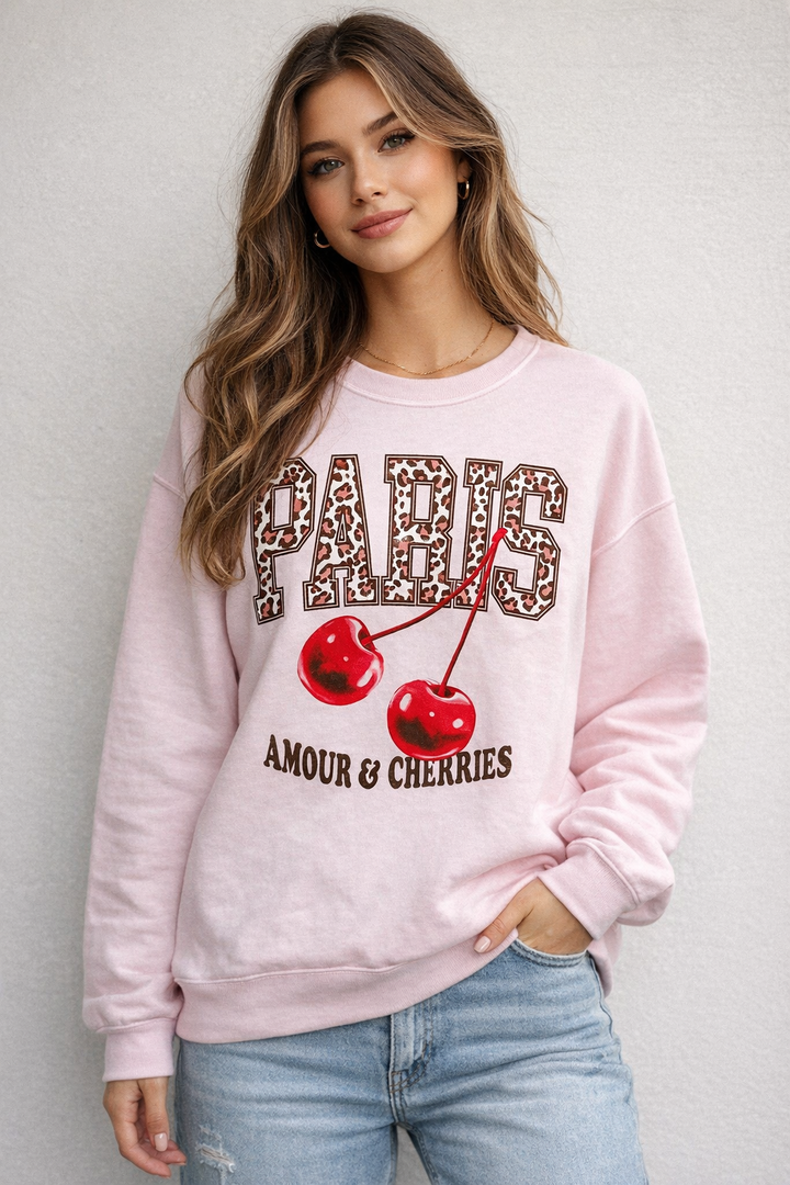 Woman wearing a pink sweatshirt with graphic design and text