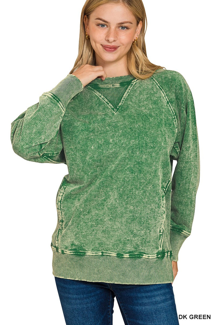 Woman wearing a green distressed sweatshirt on a white background