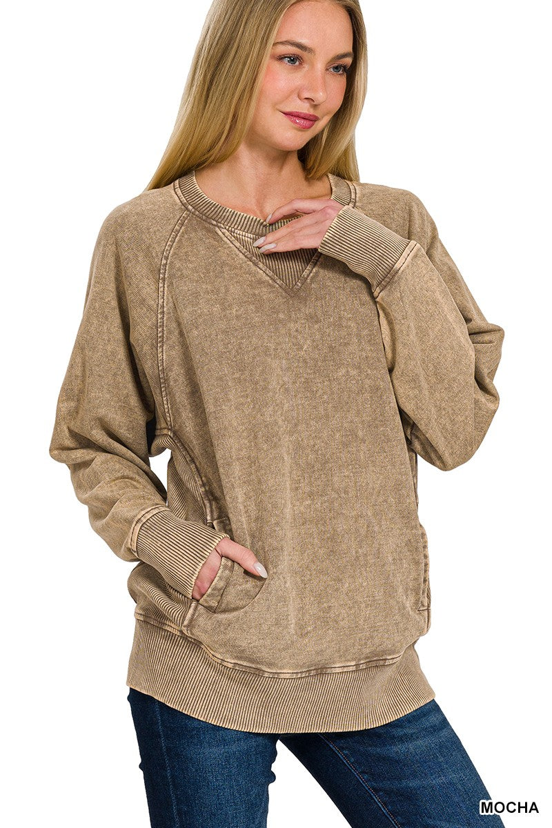 Woman wearing a beige sweatshirt with a plain background