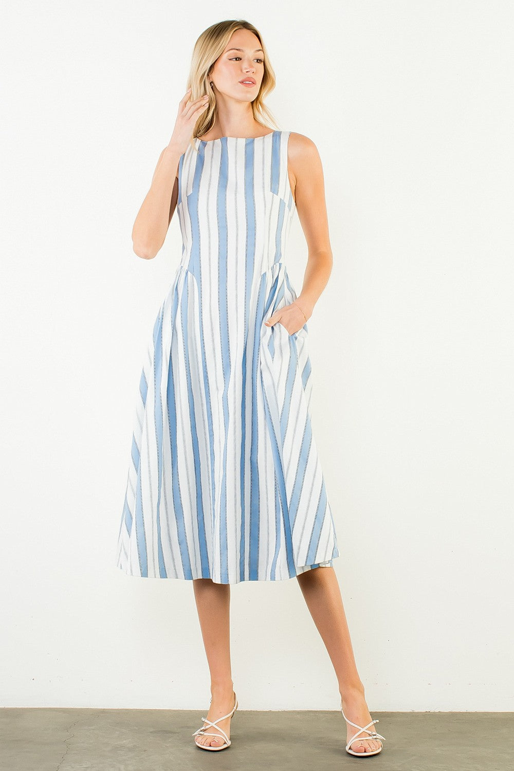 Woman wearing a blue and white striped dress against a white background