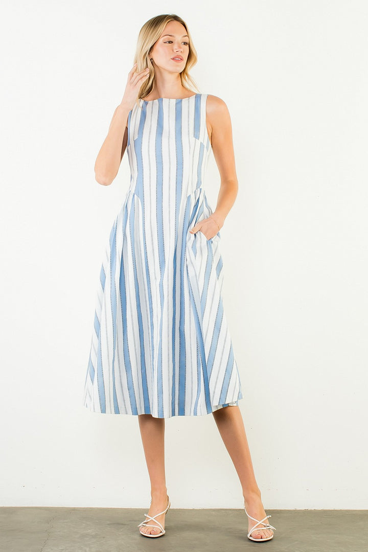 Woman wearing a blue and white striped dress against a white background