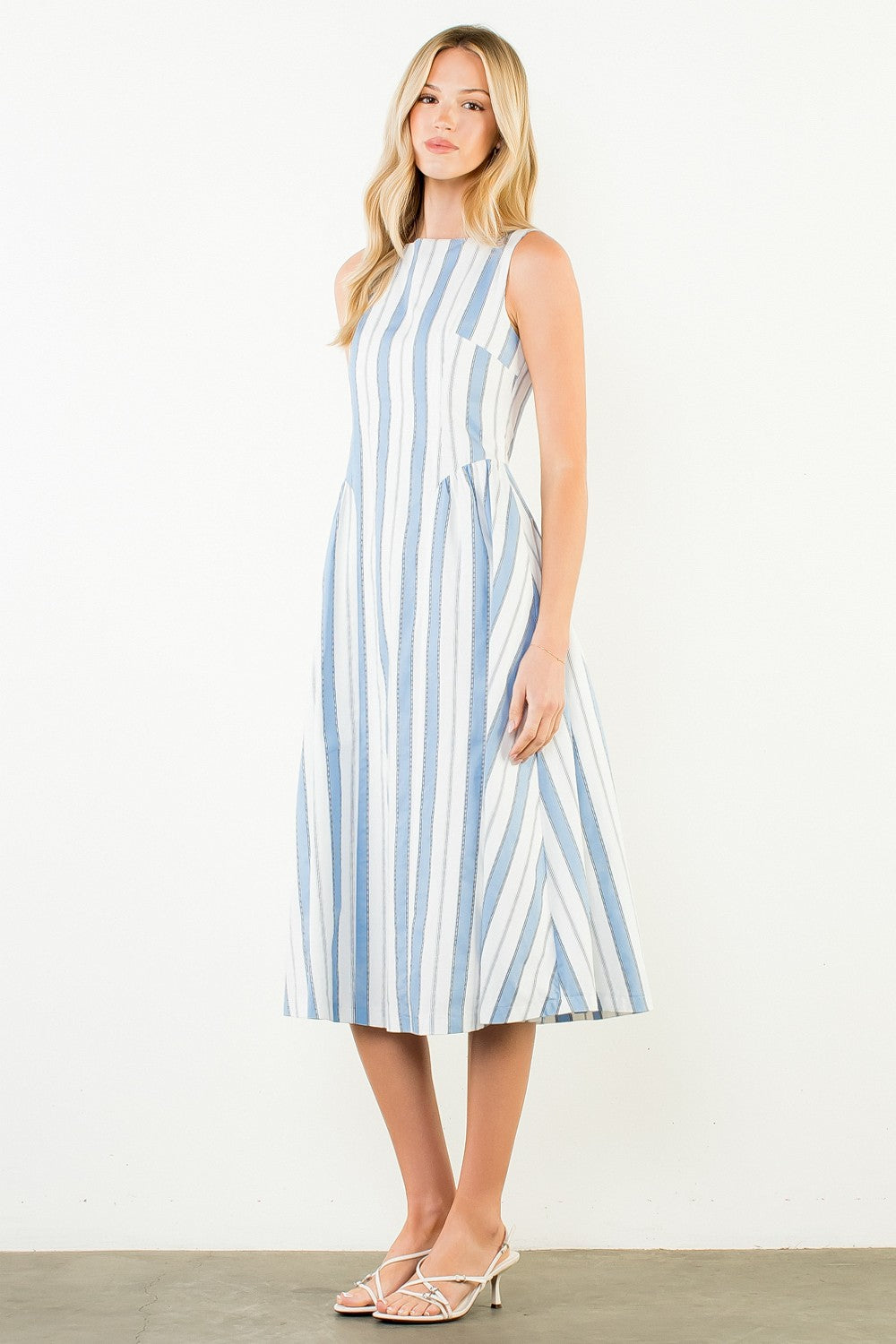 Woman wearing a blue and white striped dress on a plain background