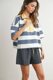 Woman wearing a striped shirt and checkered shorts on a plain background