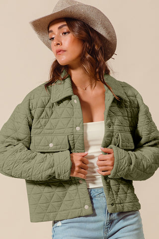 Woman wearing a green quilted jacket and beige hat against a beige background