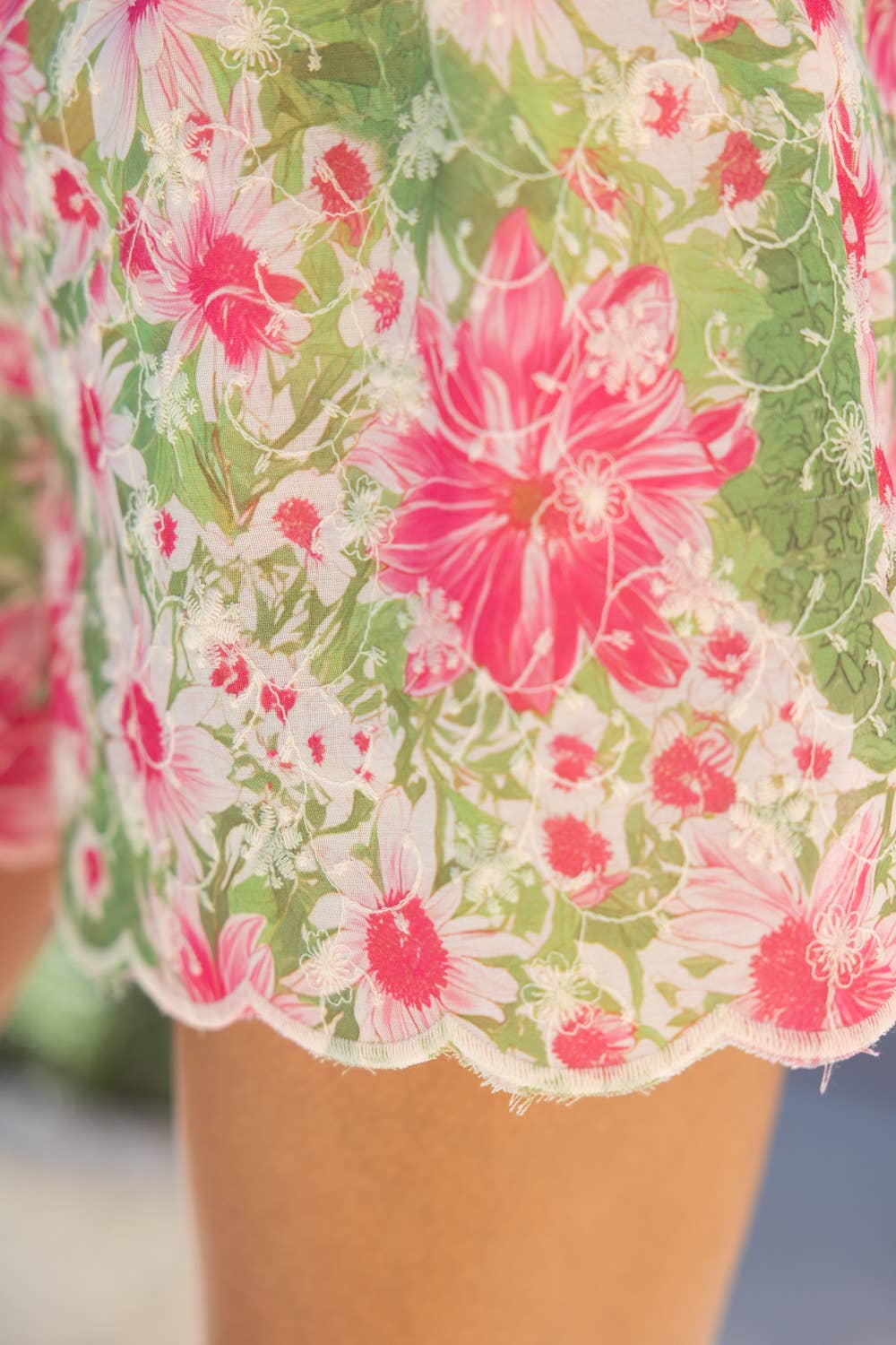 Close-up of a floral dress with pink and green flowers.