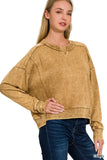 Woman wearing a tan hoodie and blue jeans on a white background