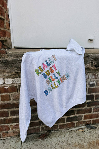 White sweatshirt with colorful text on a brick wall background