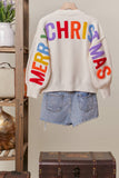 Colorful 'Merry Christmas' sweater with denim shorts on a neutral background